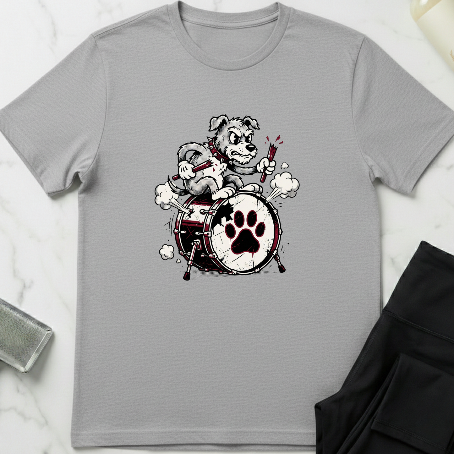 Gray t-shirt with a graphic of a dog playing drums on a white marble surface. Minimalist dog apparel by pemuyo.