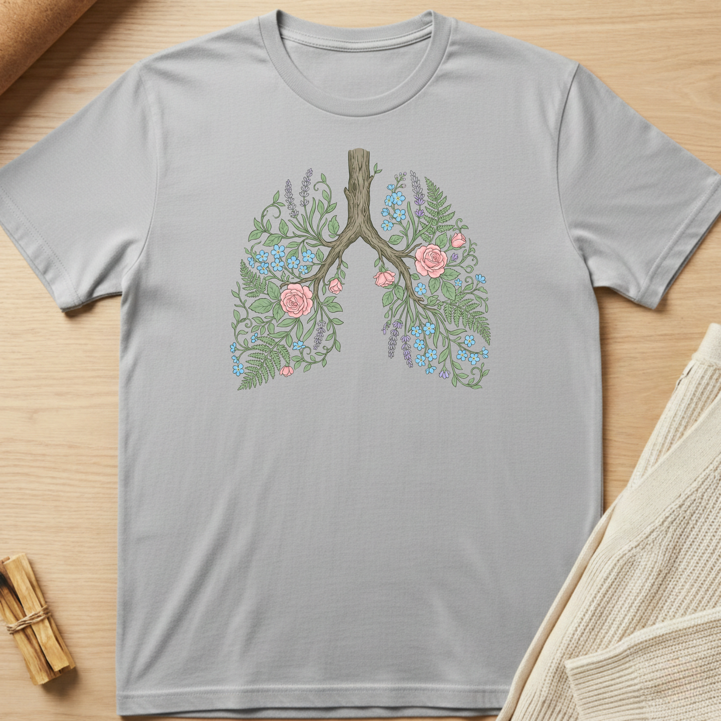 Gray t-shirt with floral lung design on a wooden surface. Minimalist yoga apparel by pemuyo.
