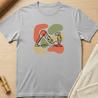 Gray t-shirt with a colorful graphic design on a wooden surface. Minimalist yoga apparel by pemuyo.