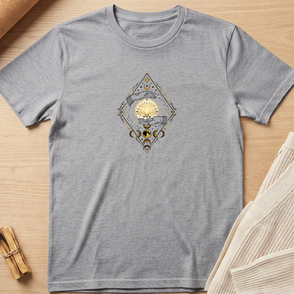 A heather gray short-sleeve t-shirt with a central graphic of a gold sun and a gray snake inside a diamond frame, laid flat on a light wood background with styled props. Minimalist yoga apparel by pemuyo.