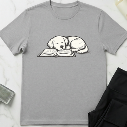 Gray t-shirt with a dog reading a book graphic on a white marble surface. Minimalist dog apparel by pemuyo.