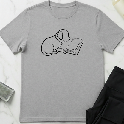 Gray t-shirt with a graphic of a dog and book a on a white marble surface. Minimalist dog apparel by pemuyo.