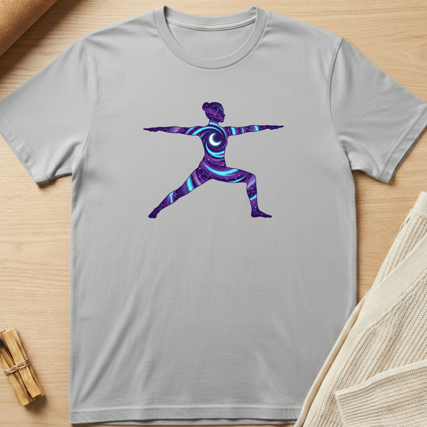 Gray t-shirt with a colorful yoga pose design on a wooden surface. Minimalist yoga apparel by pemuyo.