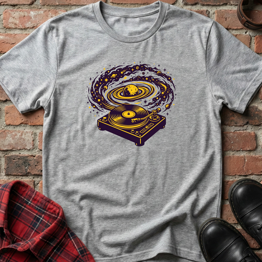 Gray t-shirt with a graphic design of a turntable on a brick surface. Minimalist music apparel by pemuyo.