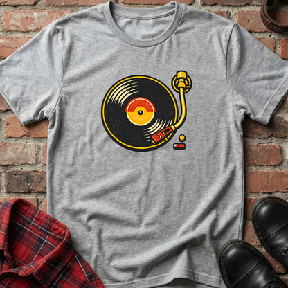 Gray t-shirt with a vinyl record graphic on a brick wall background. Minimalist music apparel by pemuyo.