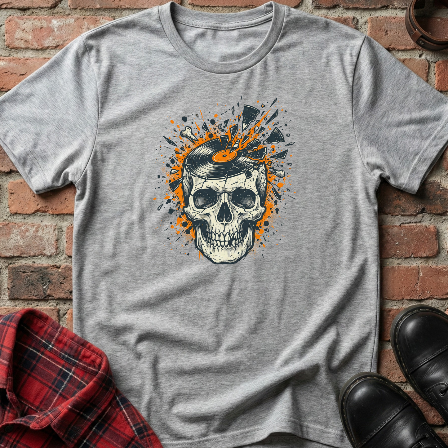 Gray t-shirt with a skull design on a brick wall background. Minimalist music apparel by pemuyo.