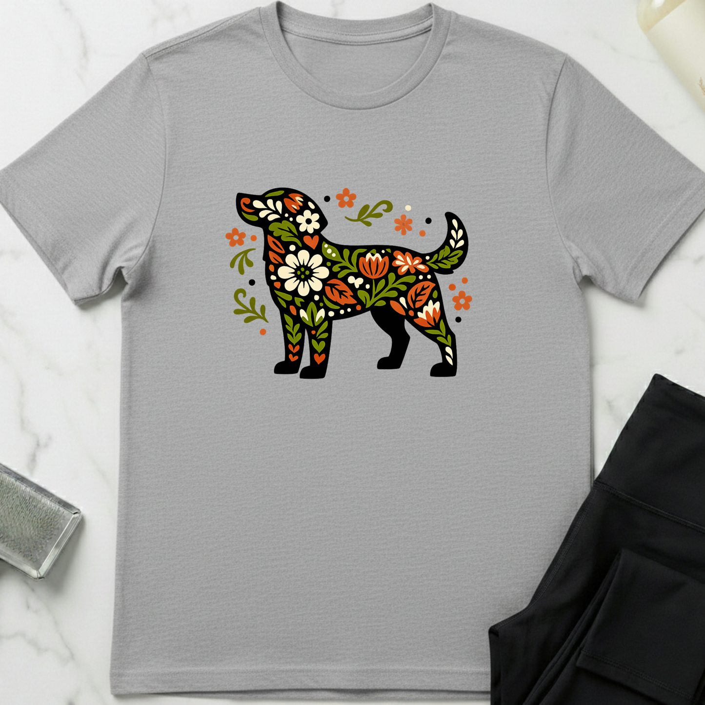 Gray t-shirt with a colorful floral dog design on a marble surface. Minimalist dog apparel by pemuyo.