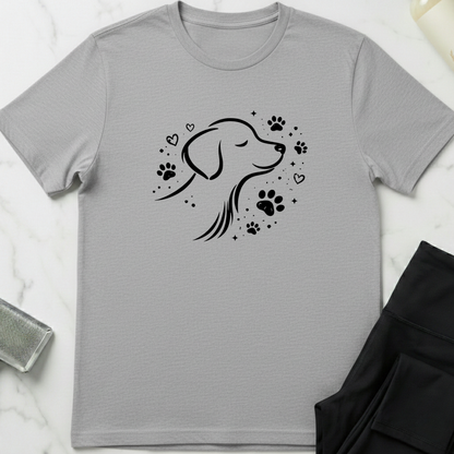 Gray t-shirt with a black dog illustration and paw prints on a white marble surface. Minimalist dog apparel by pemuyo.