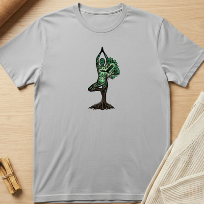 Gray t-shirt with a tree-dwelling figure design on a wooden surface. Minimalist yoga apparel by pemuyo.