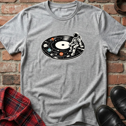 Gray t-shirt with an astronaut and solar system design on a brick wall background. Minimalist music apparel by pemuyo.