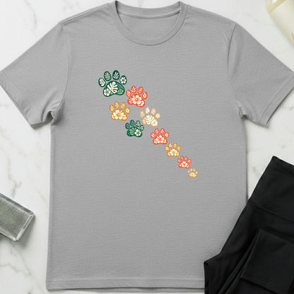 Gray t-shirt with colorful paw print design on a light gray background. Minimalist dog apparel by pemuyo.