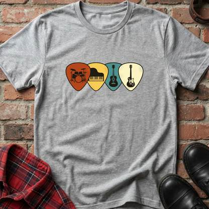 Gray t-shirt with musical instrument picks design on a brick wall background. Minimalist music apparel by pemuyo.