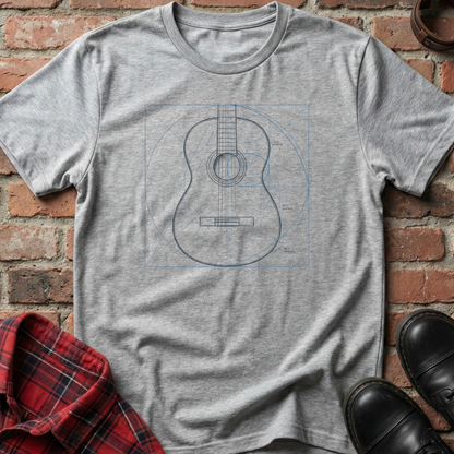 Gray t-shirt with a guitar outline design on a brick surface. Minimalist music apparel by pemuyo.
