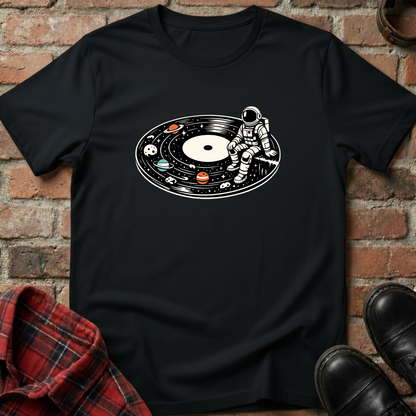 Black t-shirt with an astronaut and vinyl record design on a brick wall background. Minimalist music apparel by pemuyo.