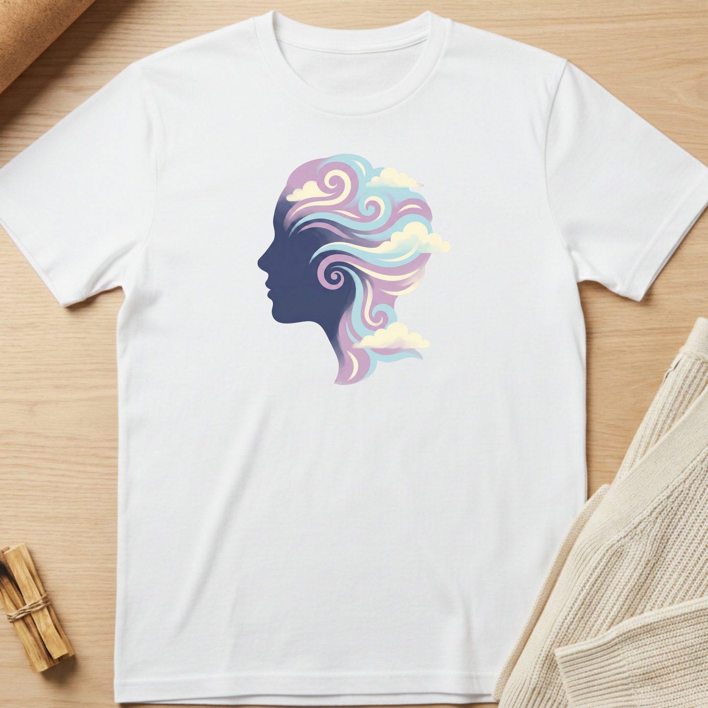 White t-shirt with a colorful silhouette design on a wooden surface. Minimalist yoga apparel by pemuyo.