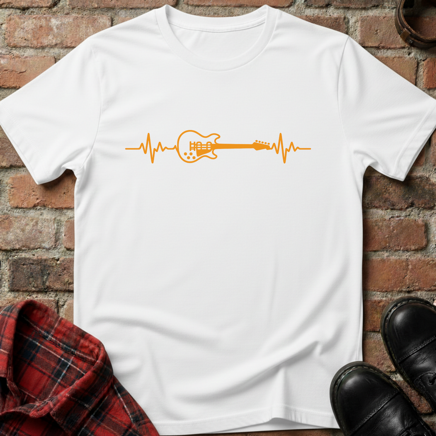 White t-shirt with orange guitar heartbeat design on a brick background. Minimalist music apparel by pemuyo.
