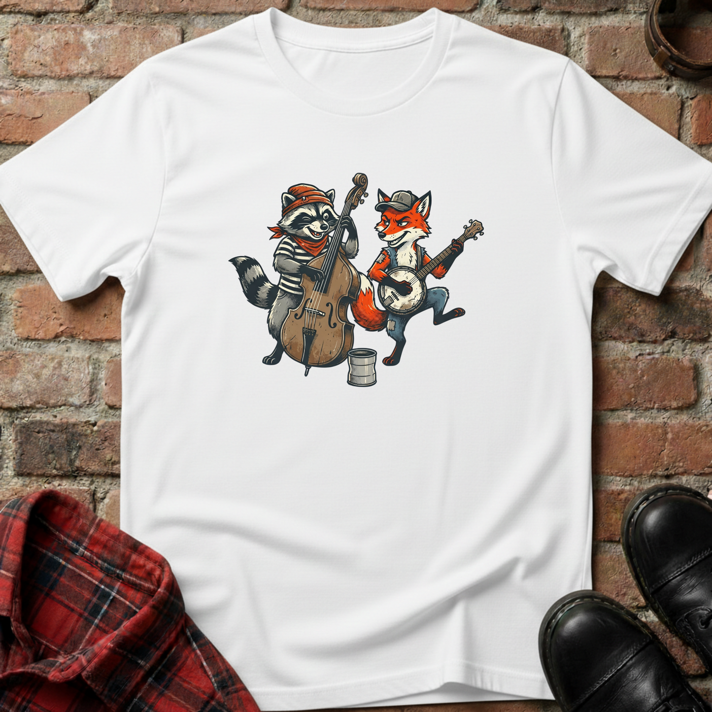 White t-shirt with cartoon raccoon and fox playing instruments on a brick wall background. Minimalist music apparel by pemuyo.