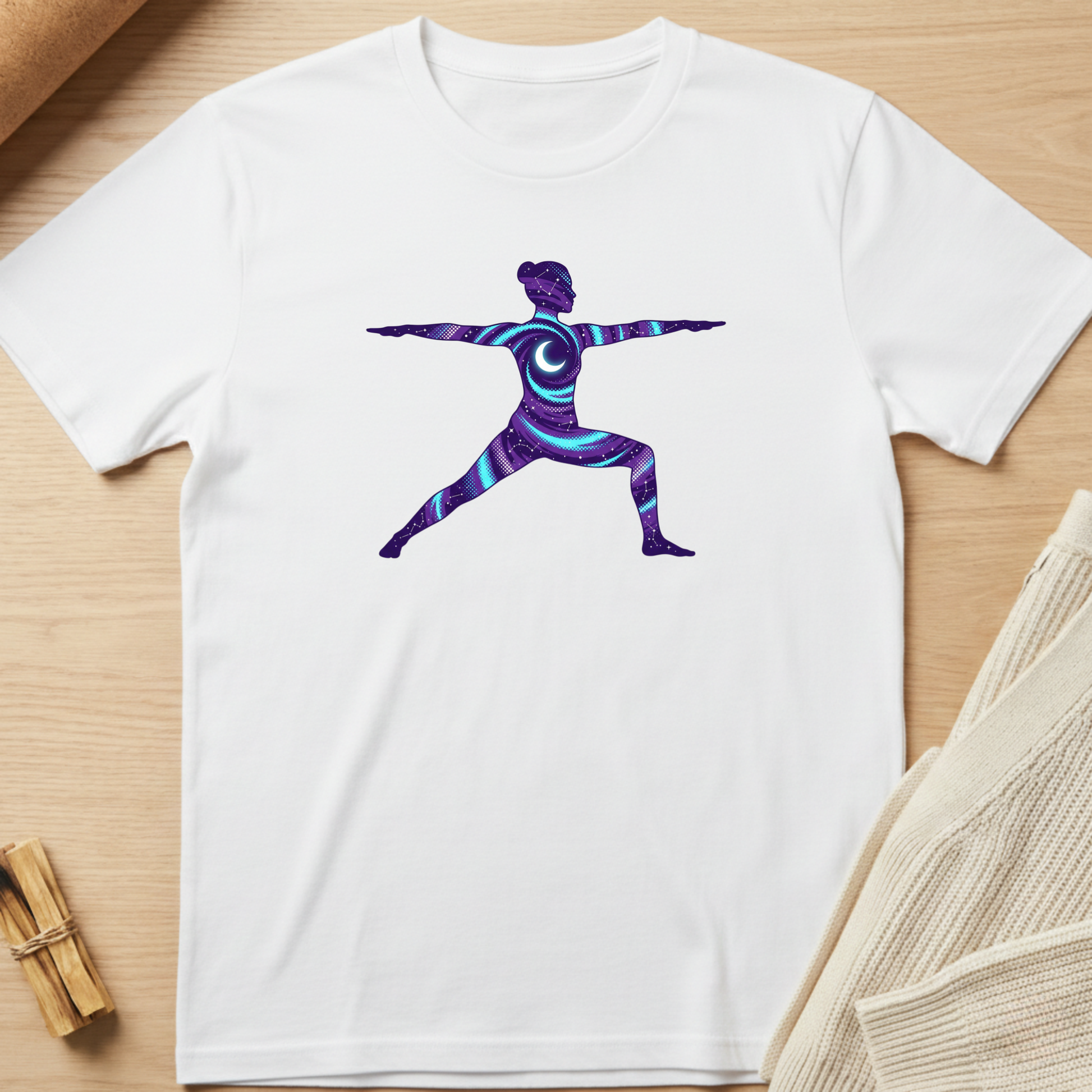 White t-shirt with a colorful yoga pose design on a wooden surface. Minimalist yoga apparel by pemuyo.