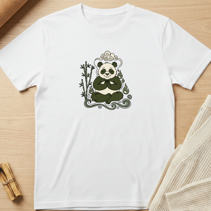 A white short-sleeve crewneck t-shirt laid flat on a light wood surface, featuring a central graphic of a panda sitting cross-legged with bamboo and decorative swirls in dark green and gray. Minimalist yoga apparel by pemuyo.
