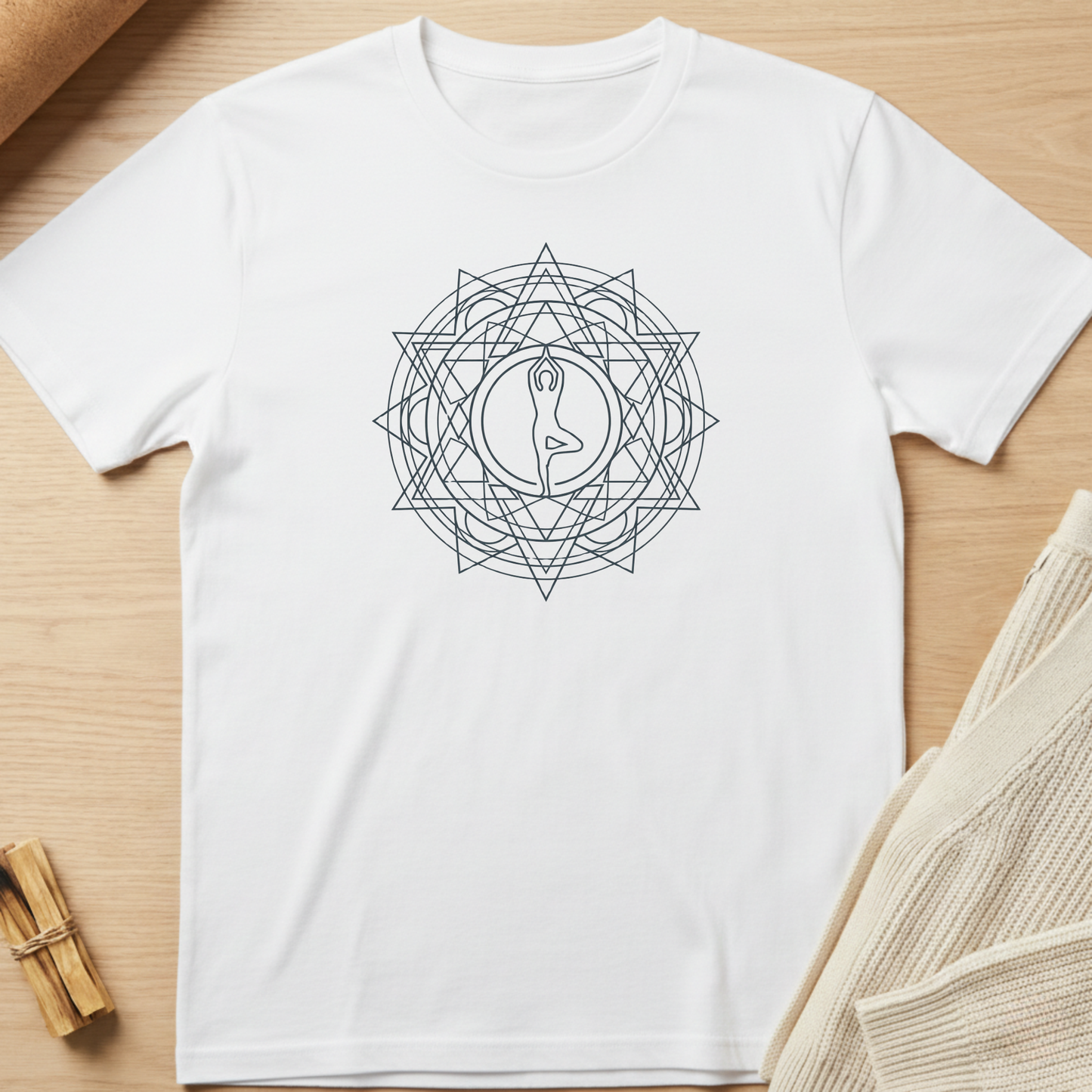 White t-shirt with a geometric design on a wooden surface. Minimalist yoga apparel by pemuyo.