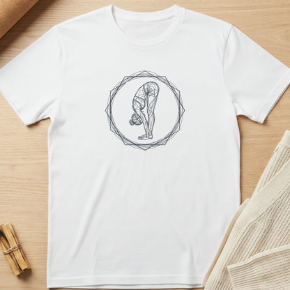 A white short-sleeve crewneck t-shirt with a black line art graphic of a person in a yoga forward bend pose inside a geometric circle, laid flat on a light wood background with neutral props. Minimalist yoga apparel by pemuyo.