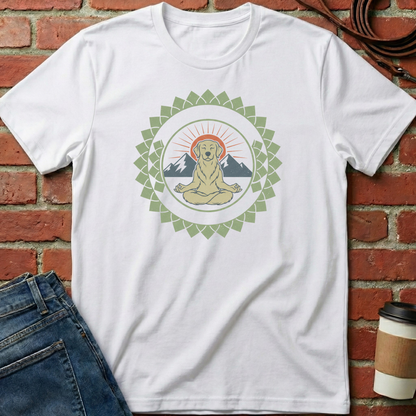 White t-shirt with a graphic design of a meditating dog surrounded by mountains and a sun, placed against a brick wall. Minimalist yoga apparel by pemuyo.