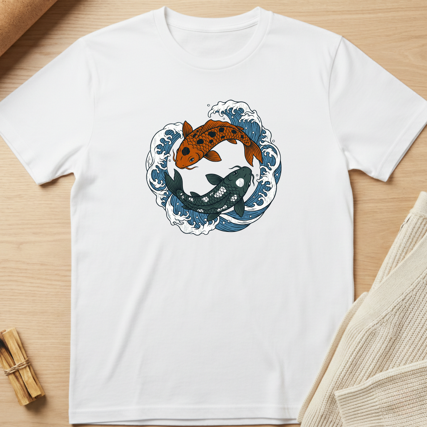White t-shirt with a graphic of two koi fish in waves on a wooden surface. Minimalist yoga apparel by pemuyo.