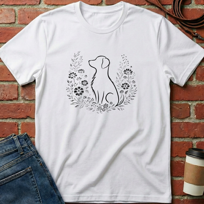 White t-shirt with a dog silhouette and floral wreath design against a brick wall. Minimalist dog apparel by pemuyo.