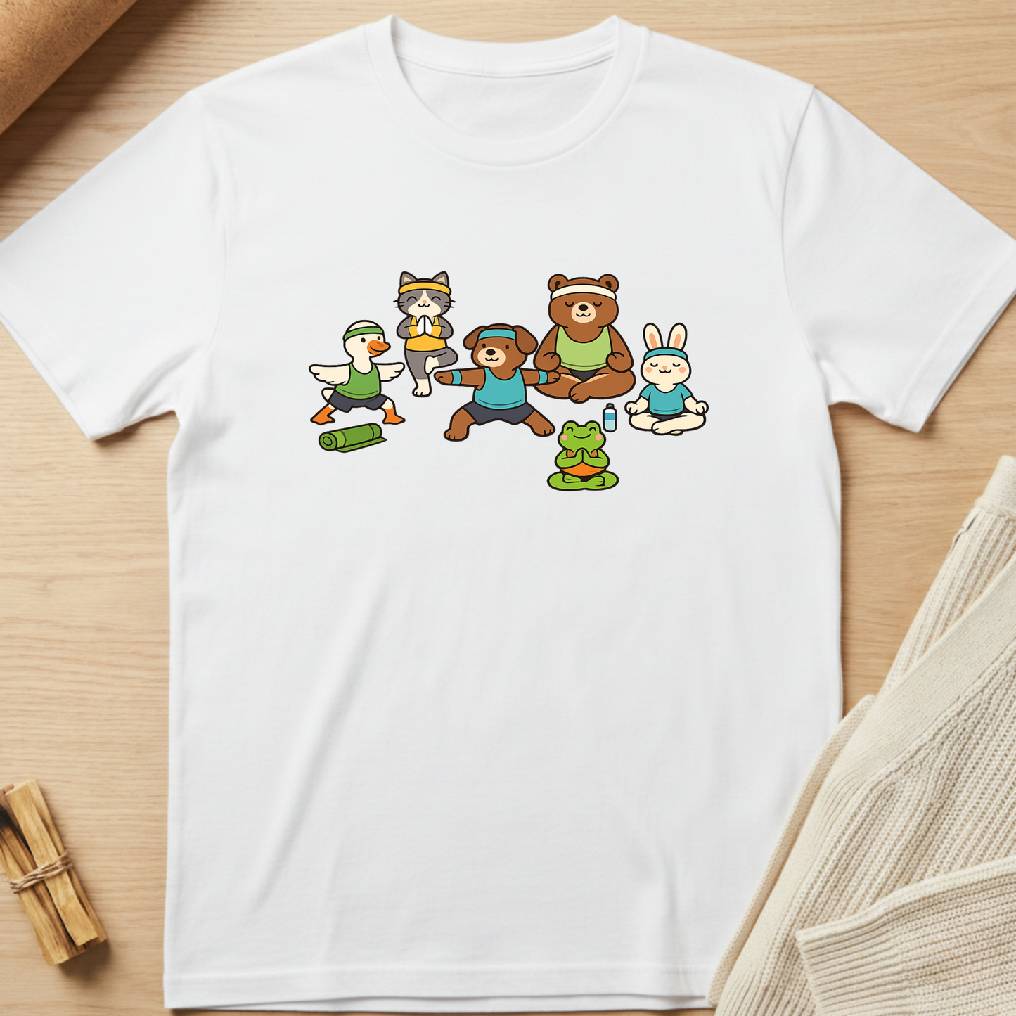 White t-shirt with cartoon characters on a wooden surface. Minimalist yoga apparel by pemuyo.