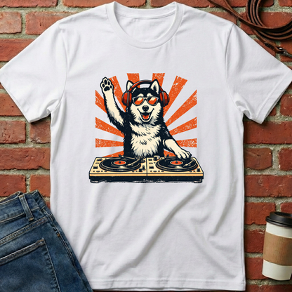 White t-shirt with a dog DJ graphic on a brick wall background. Minimalist dog apparel by pemuyo.