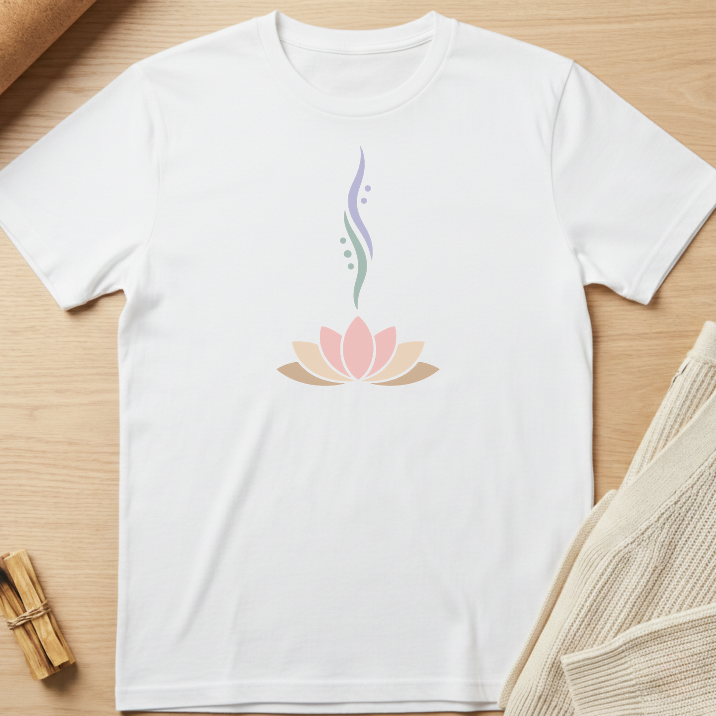 White t-shirt with a pink lotus flower design on a wooden surface. Minimalist yoga apparel by pemuyo.