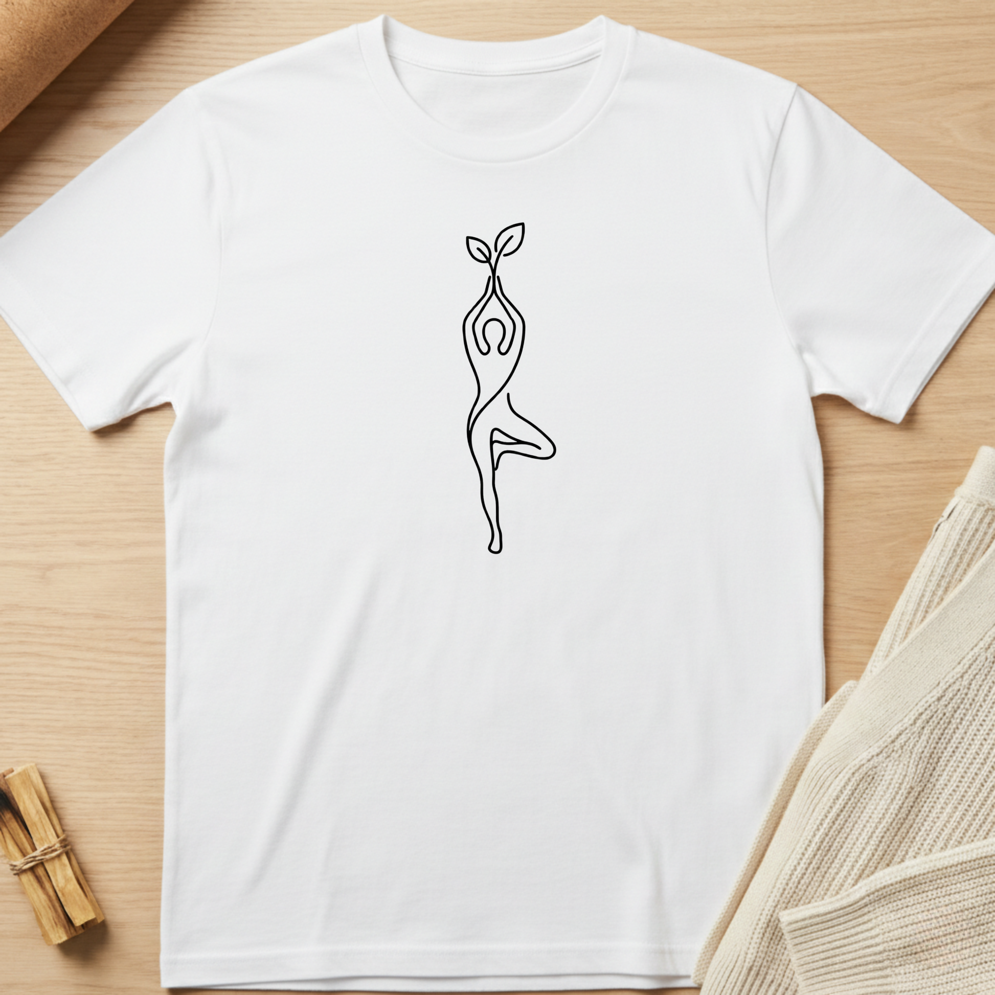 White t-shirt with a black line art design of a person holding a plant on a wooden surface. Minimalist yoga apparel by pemuyo.