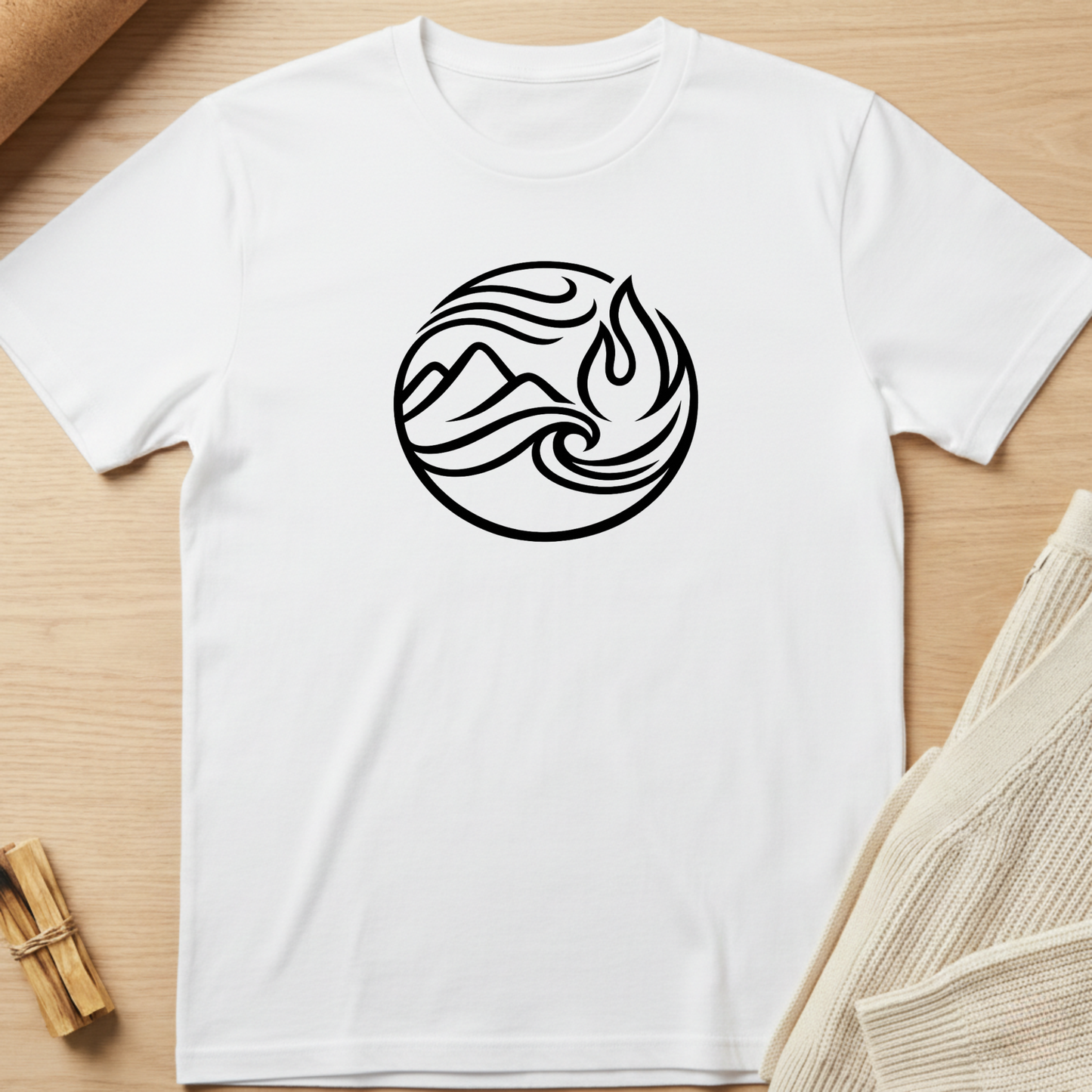 White t-shirt with a black circular design featuring a flame and mountain on a wooden surface. Minimalist yoga apparel by pemuyo.