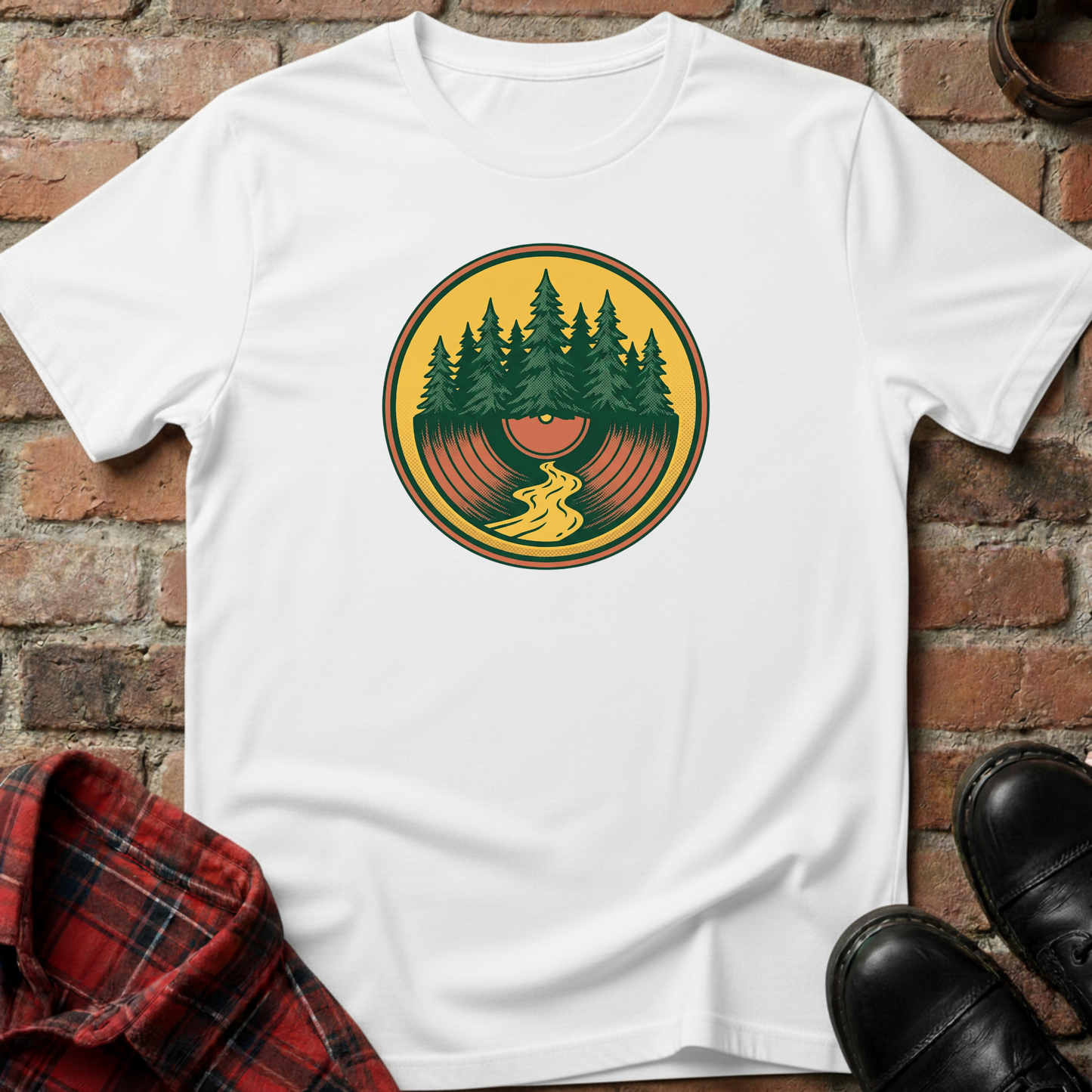 White t-shirt with a graphic design of trees and a record on a brick surface. Minimalist music apparel by pemuyo.