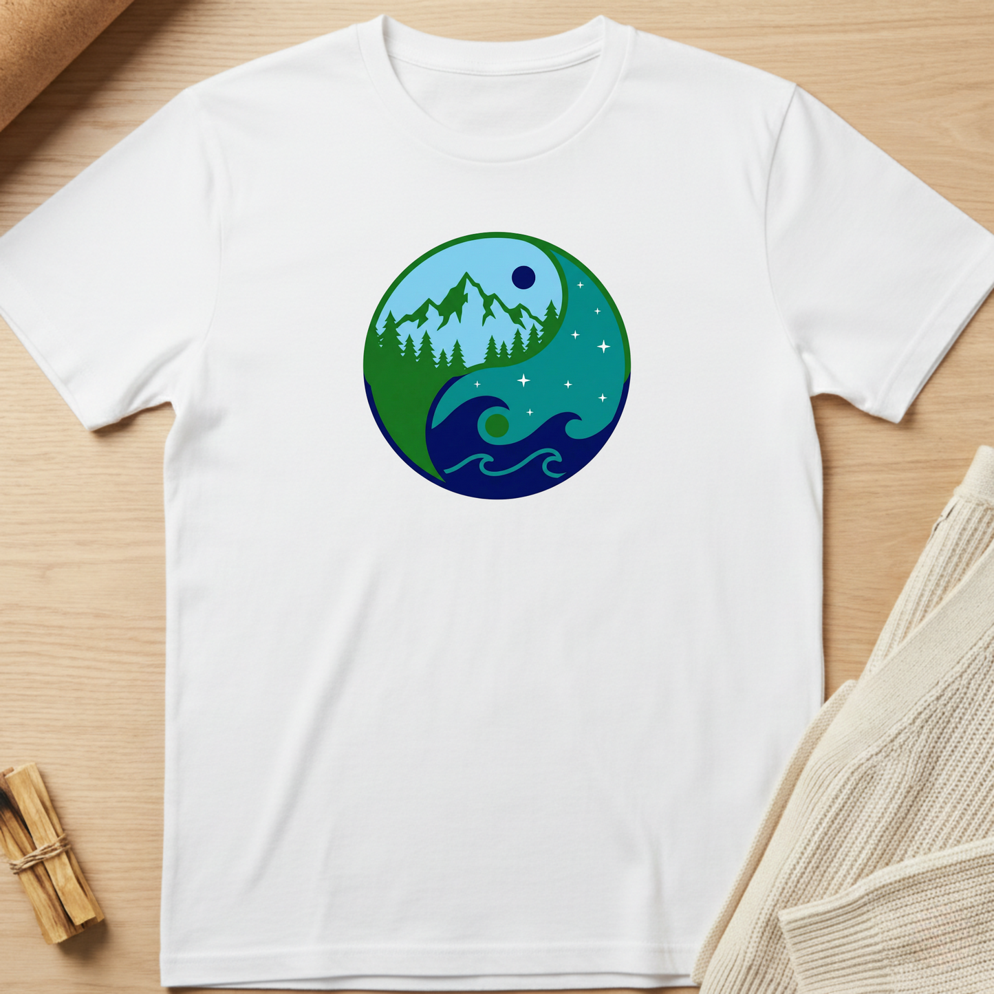 White t-shirt with a nature-themed graphic on a wooden surface. Minimalist yoga apparel by pemuyo.