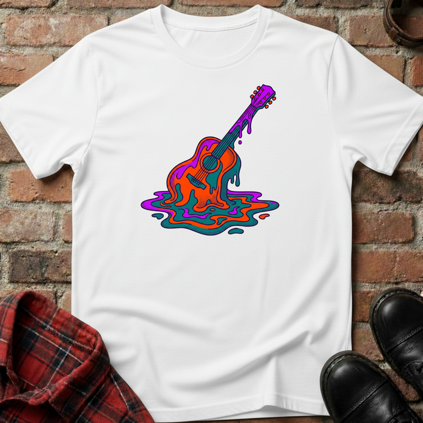 White t-shirt with a colorful guitar graphic on a brick surface. Minimalist music apparel by pemuyo.