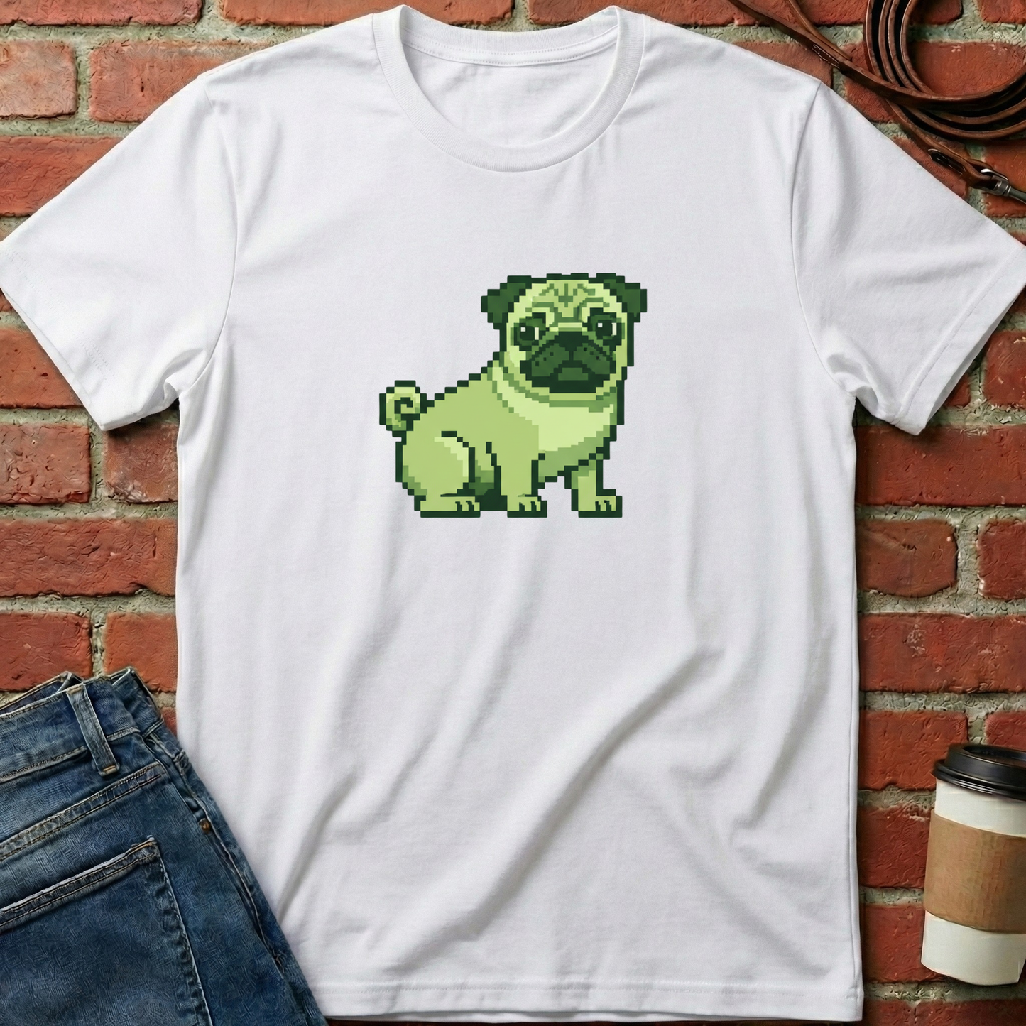 White t-shirt with a pixelated green pug design against a brick wall. Minimalist dog apparel by pemuyo.