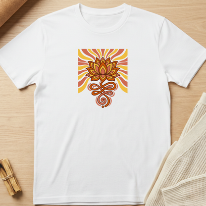 A white short-sleeve crewneck t-shirt laid flat on a light wood surface, featuring a central square graphic of a stylized orange and brown lotus flower with yellow and orange sunburst rays and a coiled snake motif below. Minimalist yoga apparel by pemuyo.