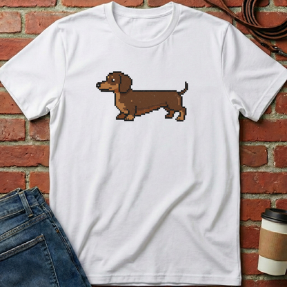White t-shirt with a pixelated dachshund graphic on a brick wall background. Minimalist dog apparel by pemuyo.