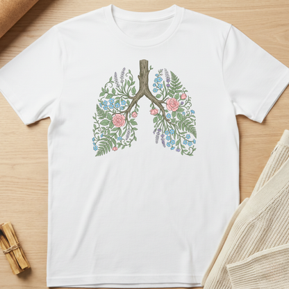 White t-shirt with floral lung design on a wooden surface. Minimalist yoga apparel by pemuyo.
