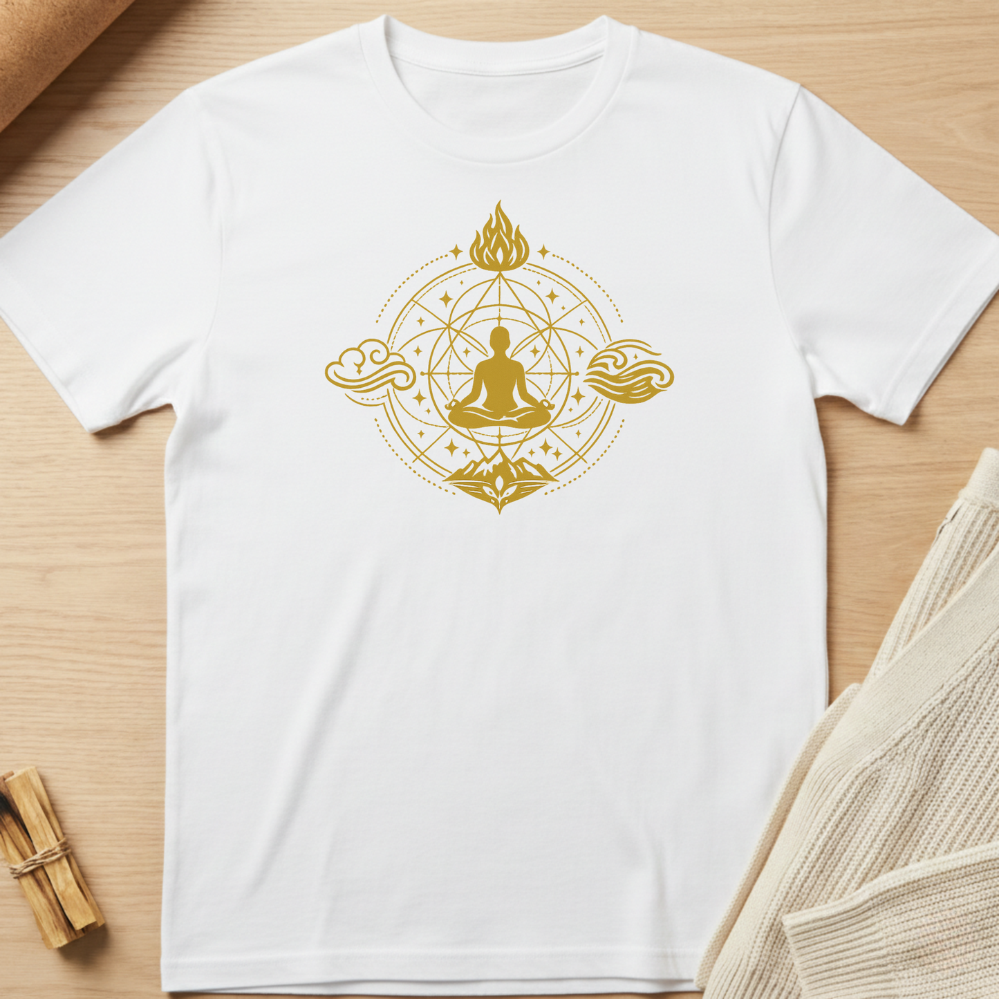 White t-shirt with gold Buddha design on a wooden surface. Minimalist yoga apparel by pemuyo.