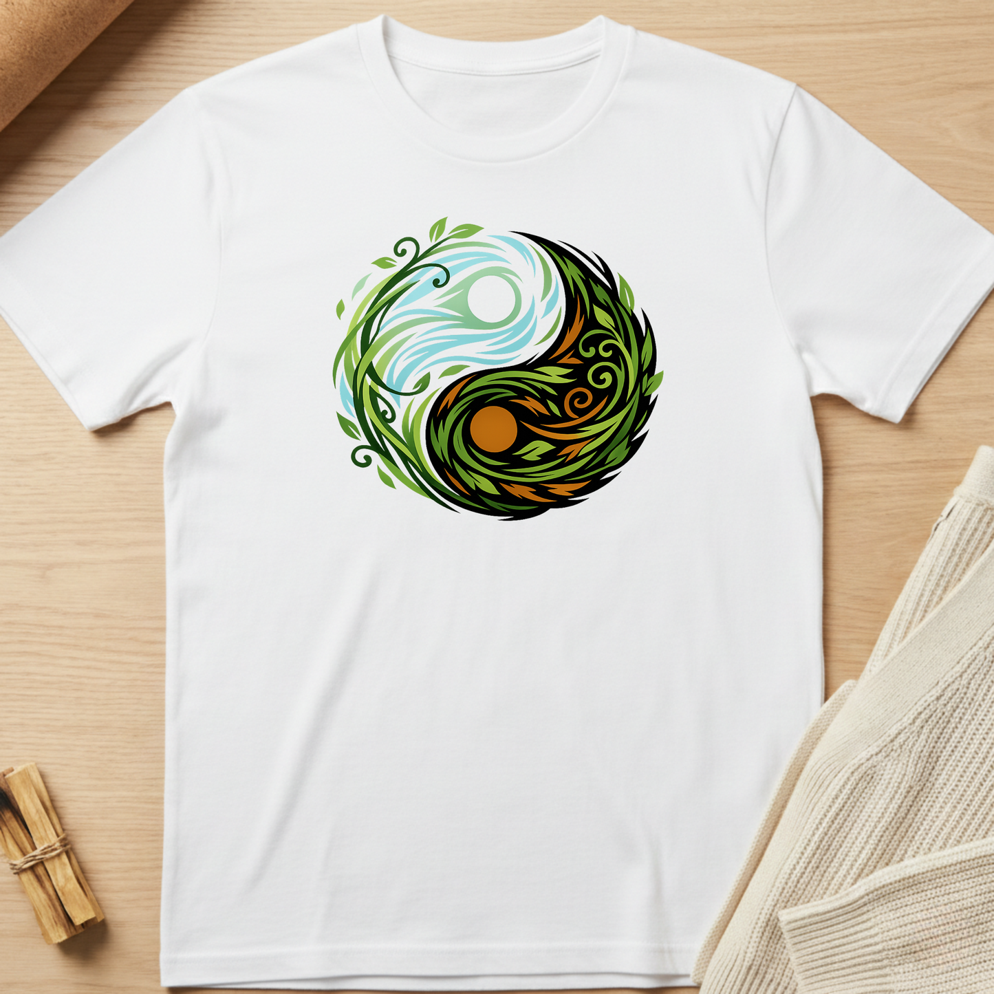 White t-shirt with a colorful yin yang design on a wooden surface. Minimalist yoga apparel by pemuyo.